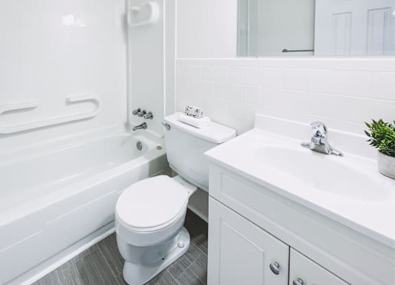 A white toilet sits next to a white sink in a bathroom.