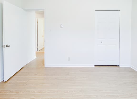 A room with a white door and a white wall.