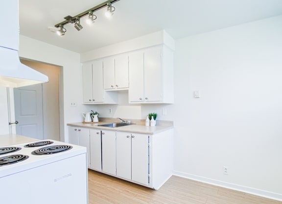 A white kitchen with a stove and cabinets.