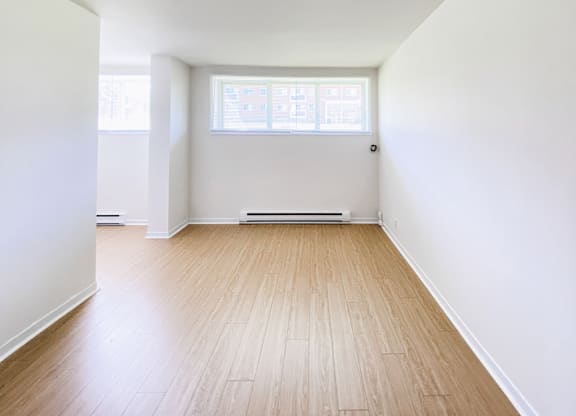 A room with wooden flooring and a window.