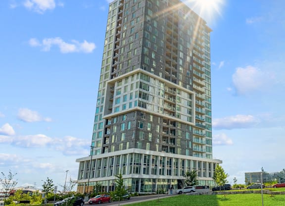A tall building with many windows is basking in the sunlight.