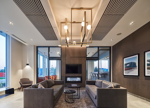 A modern living room with a brown sofa set and a large window.