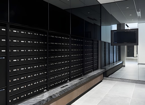 A long hallway with a row of mailboxes on the wall.