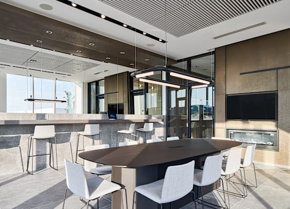 A modern dining room with a large table and chairs.