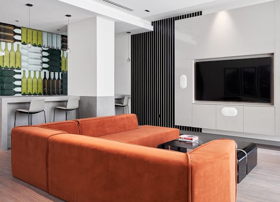 A modern living room with a brown sofa and a black television.