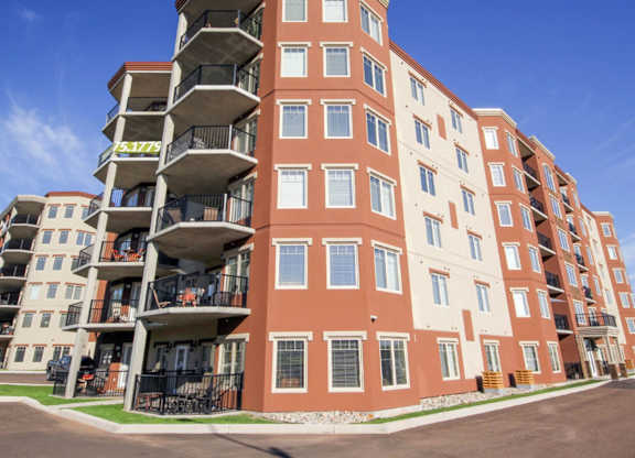 A large apartment building with multiple balconies and windows.