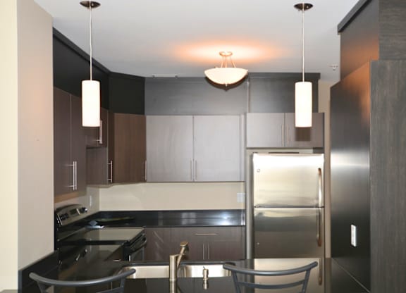 A modern kitchen with a stainless steel refrigerator and a sink.