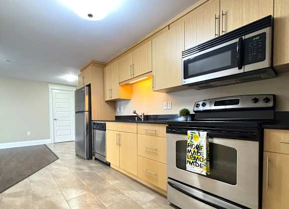 A kitchen with wooden cabinets and a tile floor.