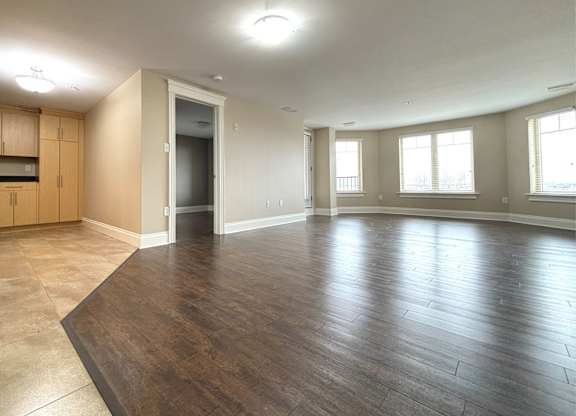 A large empty room with wooden floors and a ceiling light.