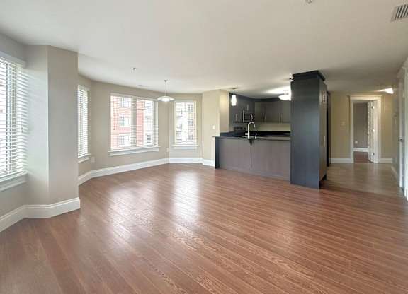 A spacious room with wooden flooring and a kitchen island.