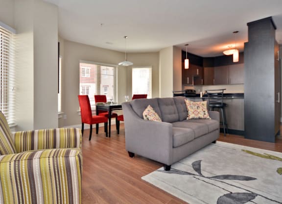 A living room with a grey couch and a striped armchair.