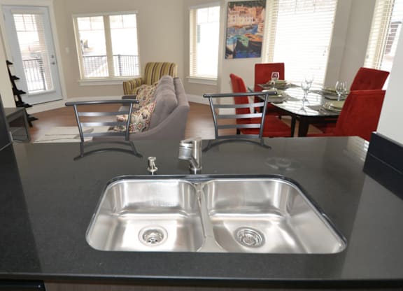 A kitchen with a sink and a dining table.