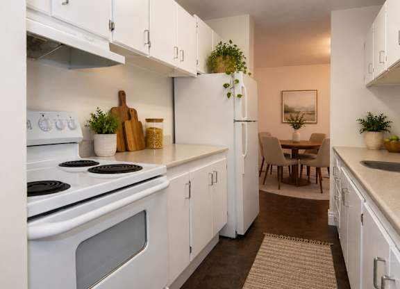 A kitchen with white cabinets and a stove top oven.