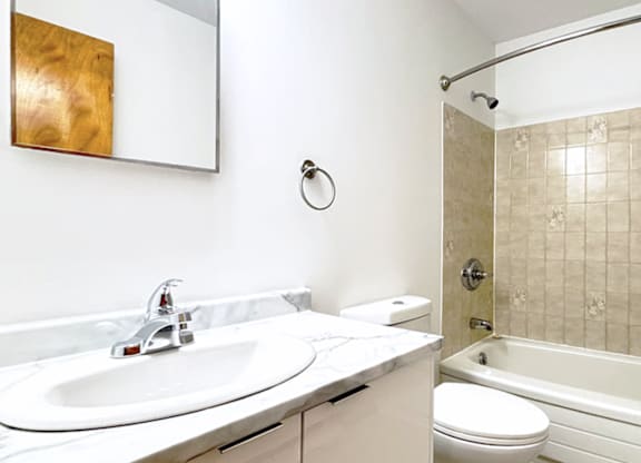 A bathroom with a sink, toilet, and tub.
