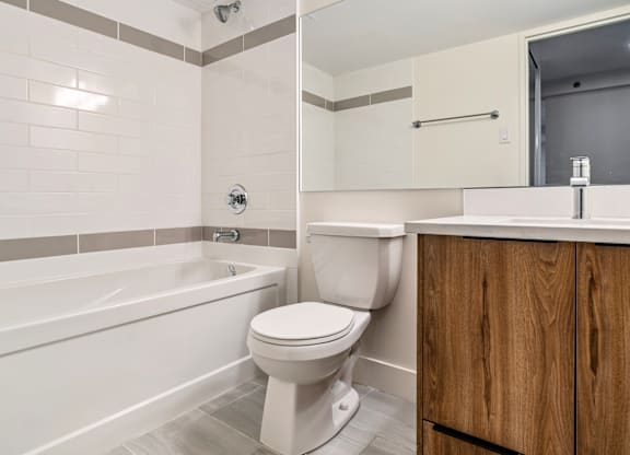 A white toilet sits next to a bathtub in a bathroom.