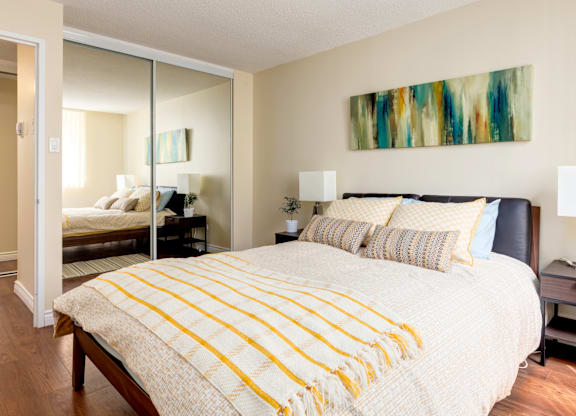 A bedroom with a large bed and a painting on the wall.