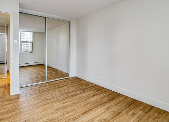 A room with a sliding door and wooden flooring.