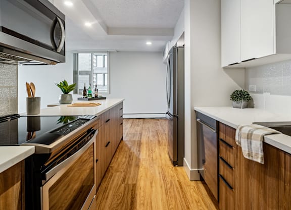 A modern kitchen with wooden cabinets and stainless steel appliances.