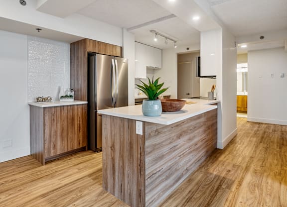 A modern kitchen with wooden cabinets and a stainless steel refrigerator.