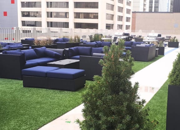 A large outdoor seating area with blue couches and a white pathway.