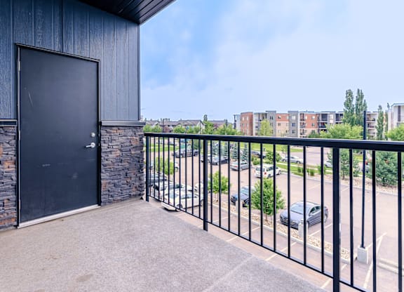 A black door is on a stone wall.