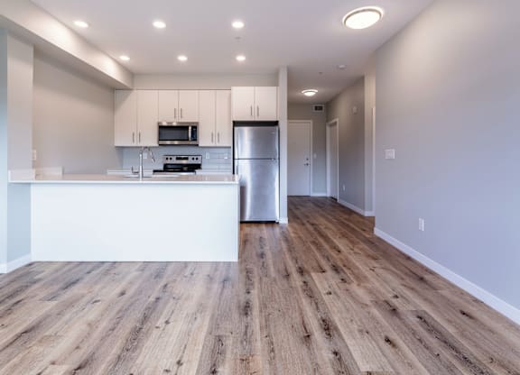 A kitchen with wooden floors and white walls.