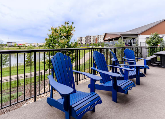 A set of blue chairs and a table are on a patio.