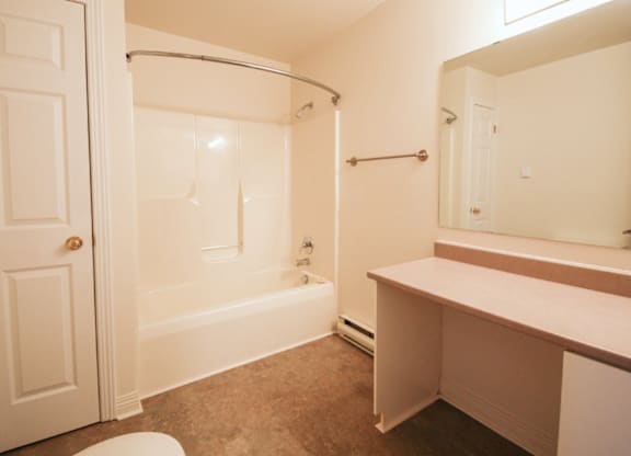 A white bathroom with a toilet, sink, and bathtub.