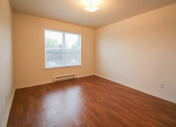 Empty room with wooden floor and a window.