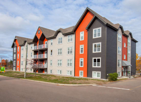 A large apartment building with grey and orange accents.