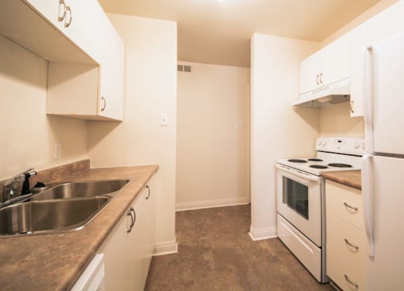 A kitchen with white appliances and a brown counter top.