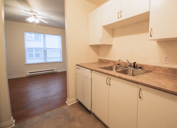 A kitchen with white cabinets and a window.