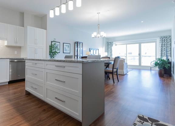 A modern kitchen with a large island and a dining area.