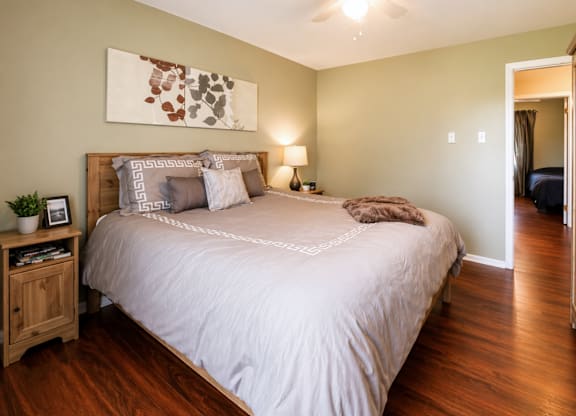 A bedroom with a large bed and a ceiling fan.