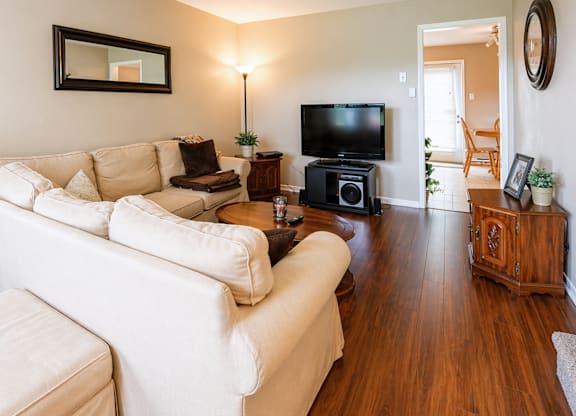 A living room with a white couch and a television.