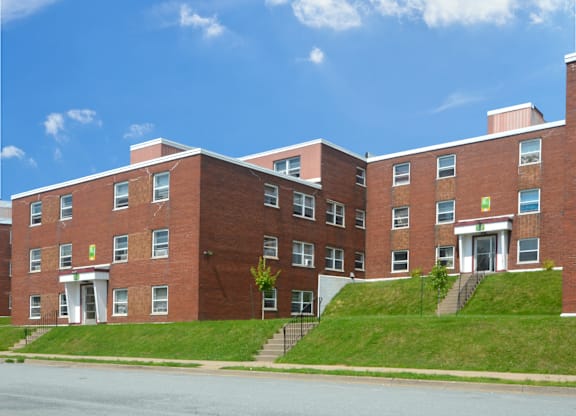 A red brick building with a green sign on the front.