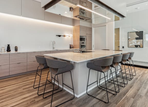A modern kitchen with a large island and bar stools.