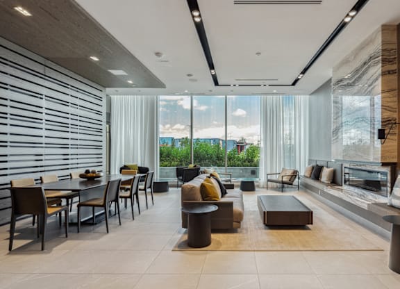 A modern living room with a dining area and a view of the outdoors.