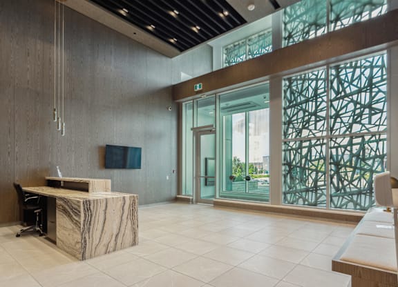 A reception area with a marble desk and a chair.