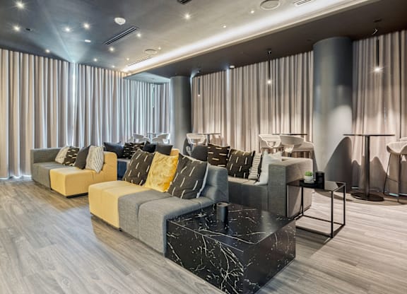A modern living room with grey and yellow sofas and a marble coffee table.