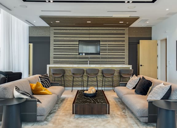 A modern living room with grey sofas and a wooden entertainment unit.