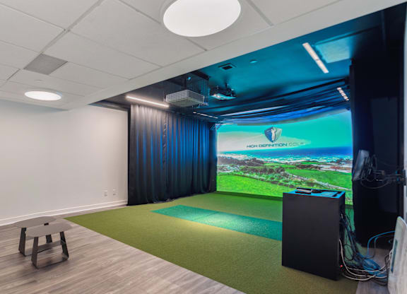 A room with a yoga mat and a projection screen showing a landscape.