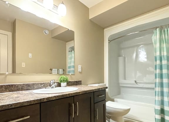 A bathroom with a sink, toilet, and bathtub.