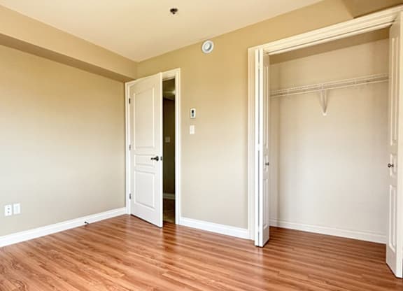 A room with a white door and a wooden floor.