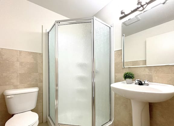 A white toilet sits next to a white sink in a bathroom.