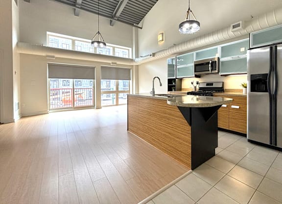 A kitchen with a black island in the middle of it.