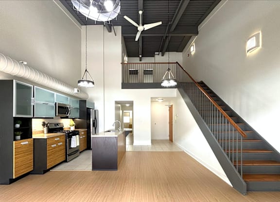 A modern kitchen with a staircase leading to the upper floor.