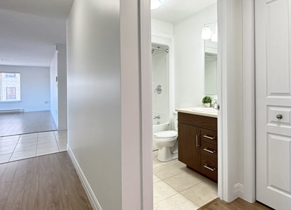 A bathroom with a toilet, sink, and mirror.