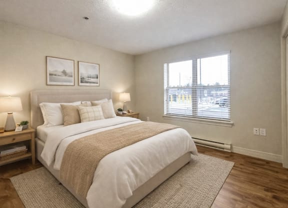 A bedroom with a large bed and two pictures on the wall.