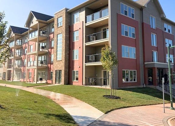 A multi-story apartment building with a walkway in front.